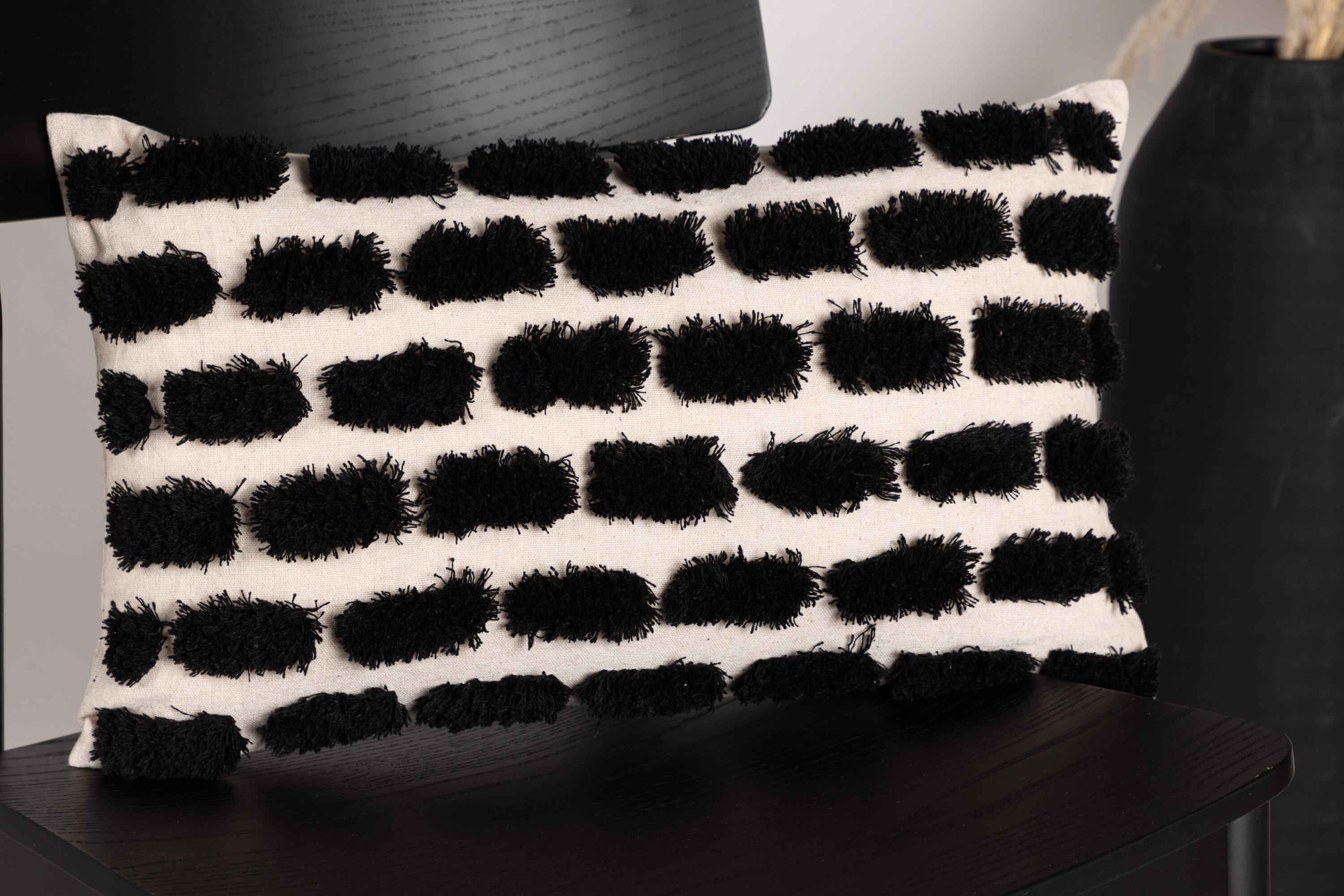 Lova housse de coussin beige, noir 30 x 50 cm en situation dans une pièce décorée
