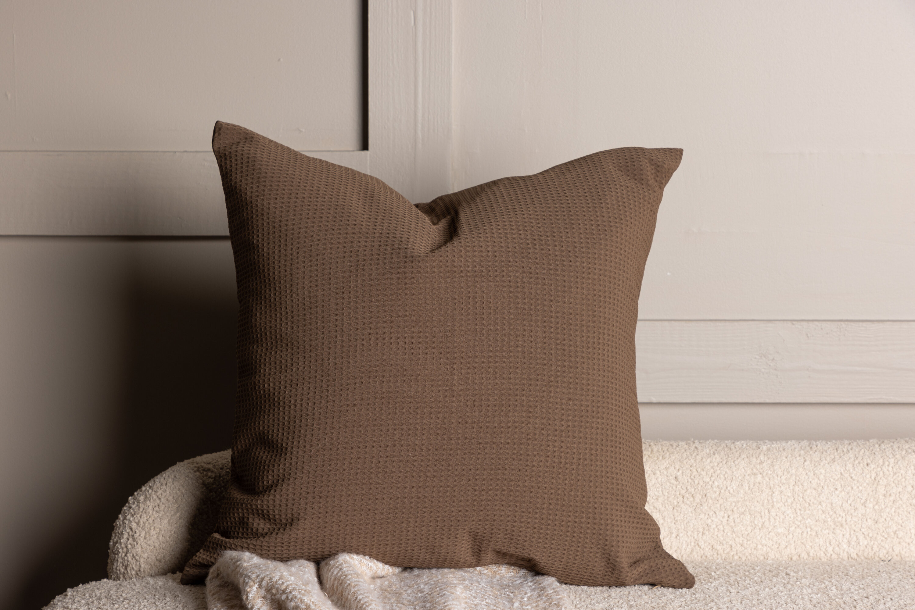 Celine housse de coussin marron foncé 50 x 50 cm en situation dans une pièce décorée