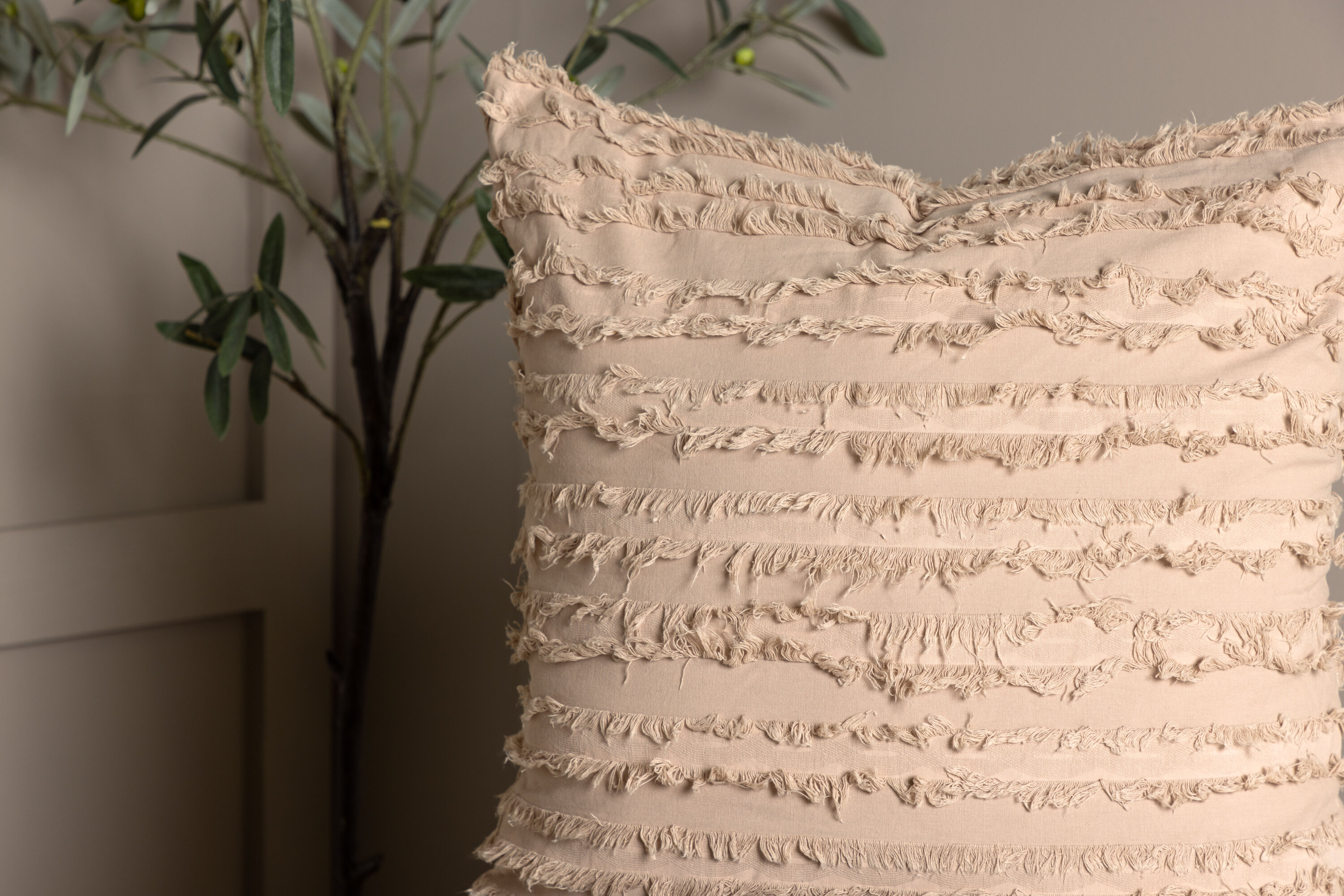 Edith housse de coussin beige 60 x 60 cm en situation dans une pièce décorée