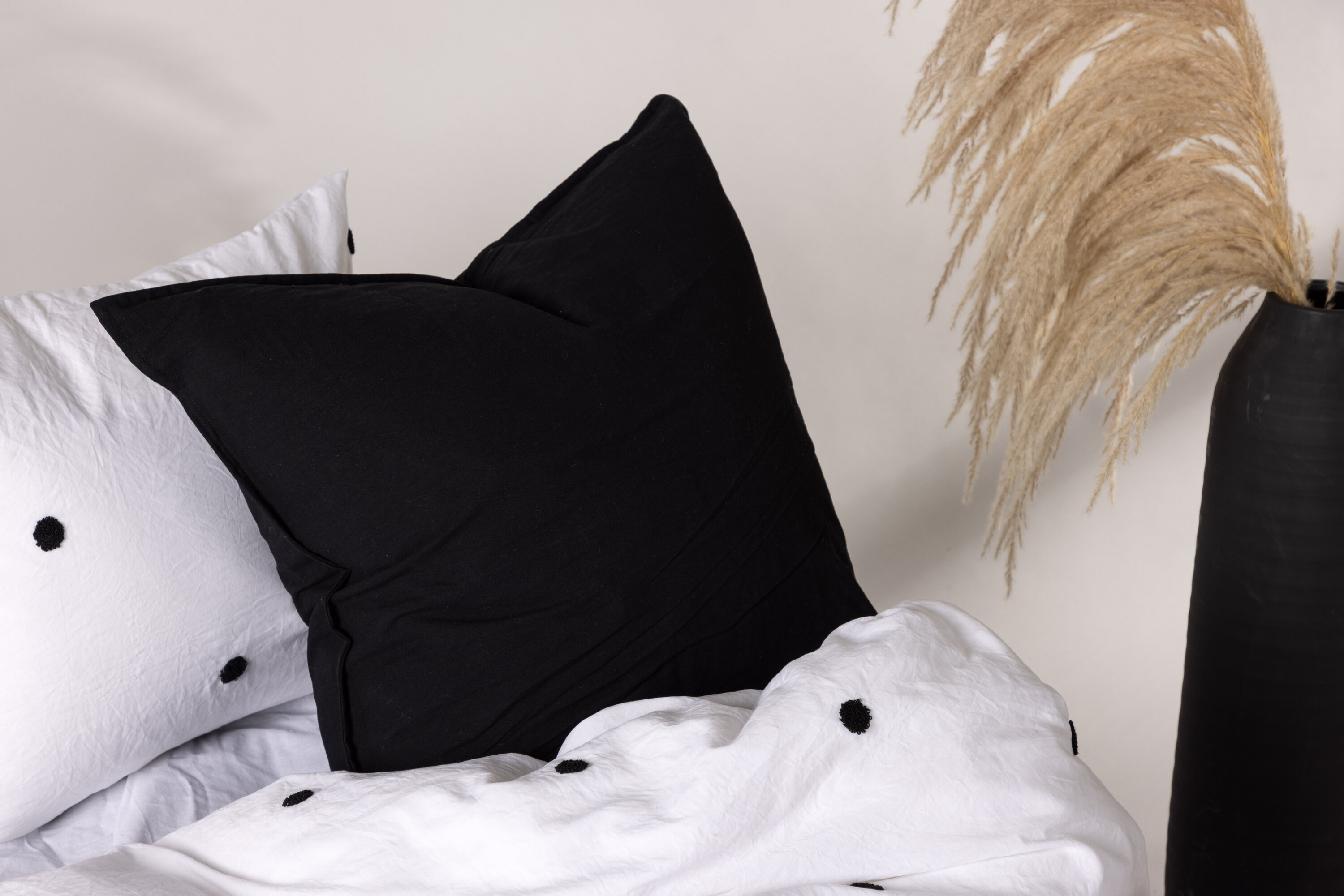 Ronja housse de coussin noir 60 x 60 cm en situation dans une pièce décorée