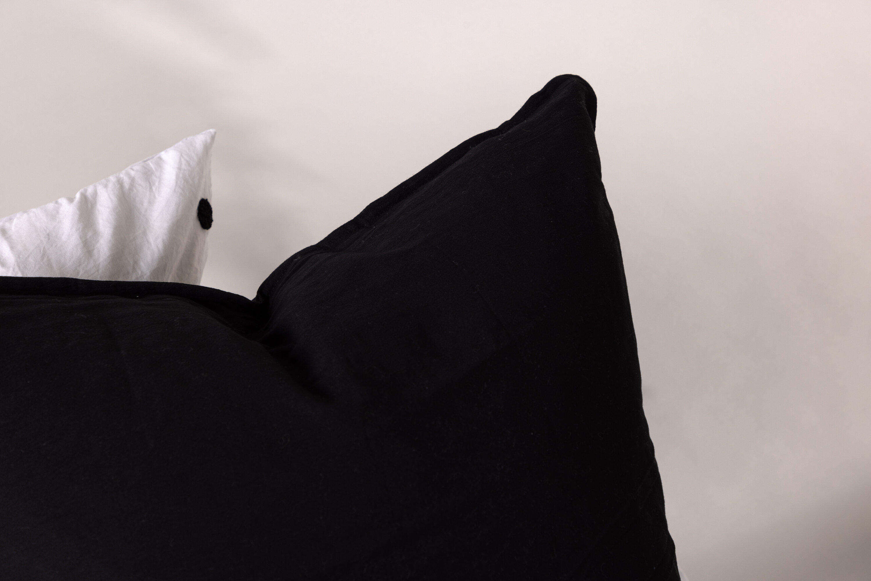 Ronja housse de coussin noir 60 x 60 cm en situation dans une pièce décorée