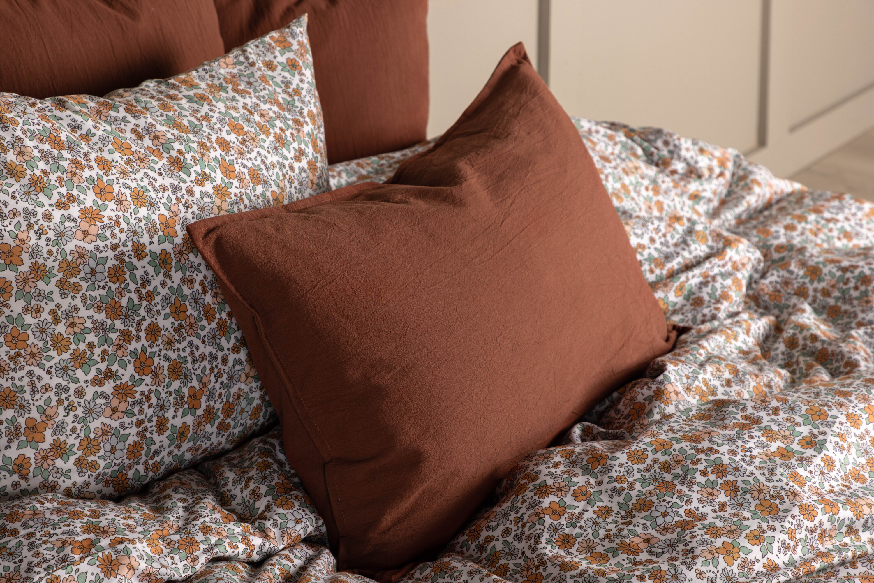 Ronja housse de coussin brun rôti 40 x 60 cm en situation dans une pièce décorée