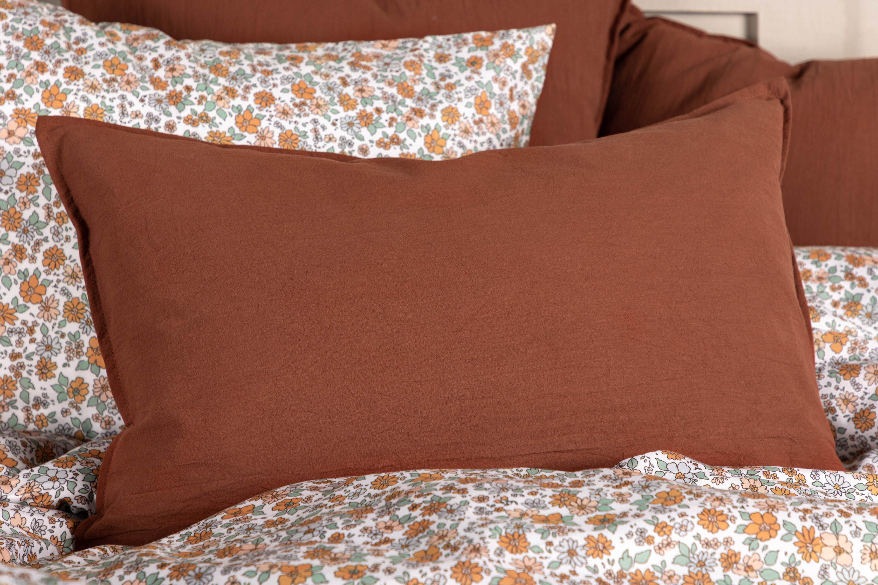 Ronja housse de coussin brun rôti 40 x 60 cm en situation dans une pièce décorée