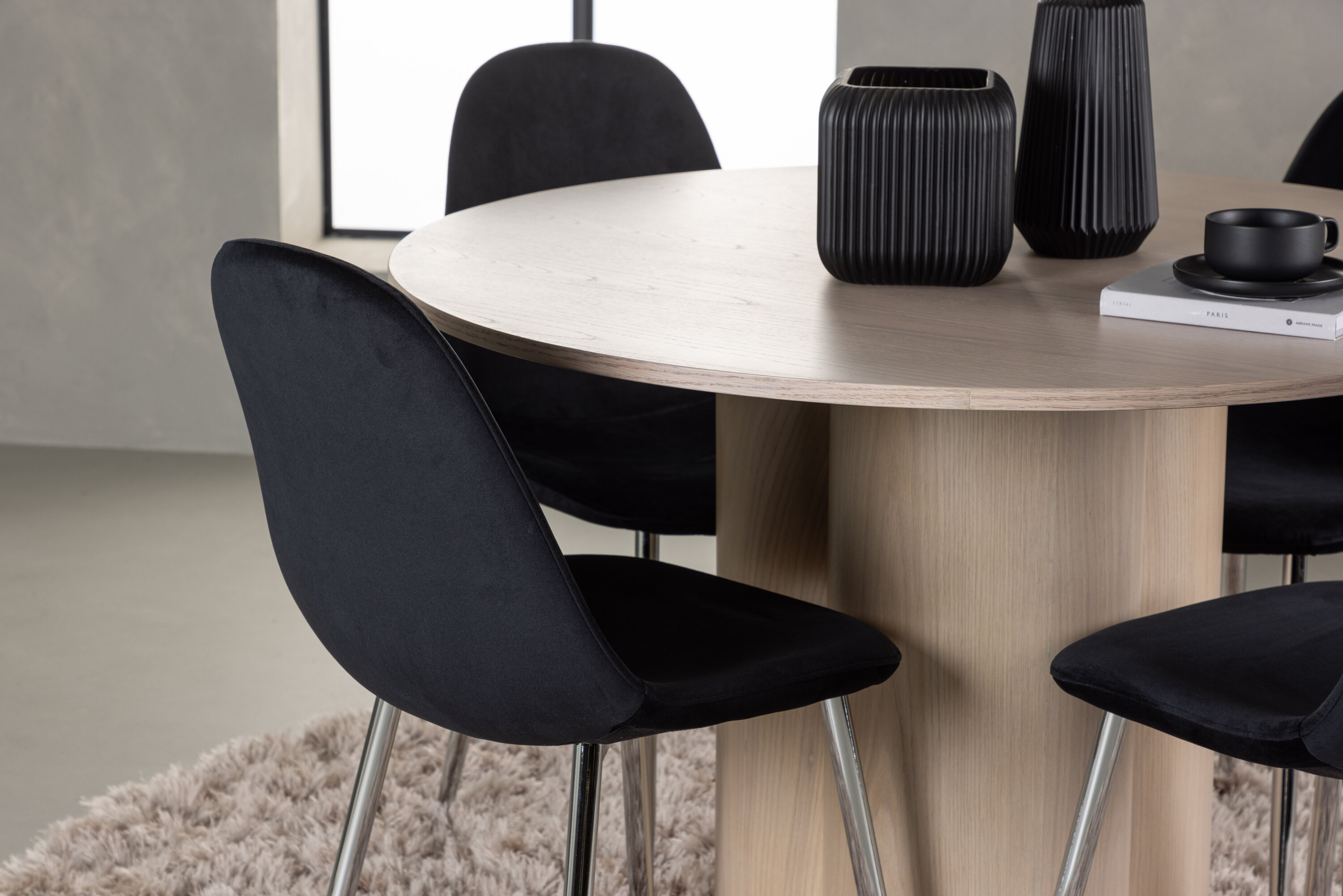 Olivia, Polar ensemble repas rond blanchi, noir, argenté Table : ⌀110 Chaise : 52 x 90 x 45 cm en situation dans une pièce décorée