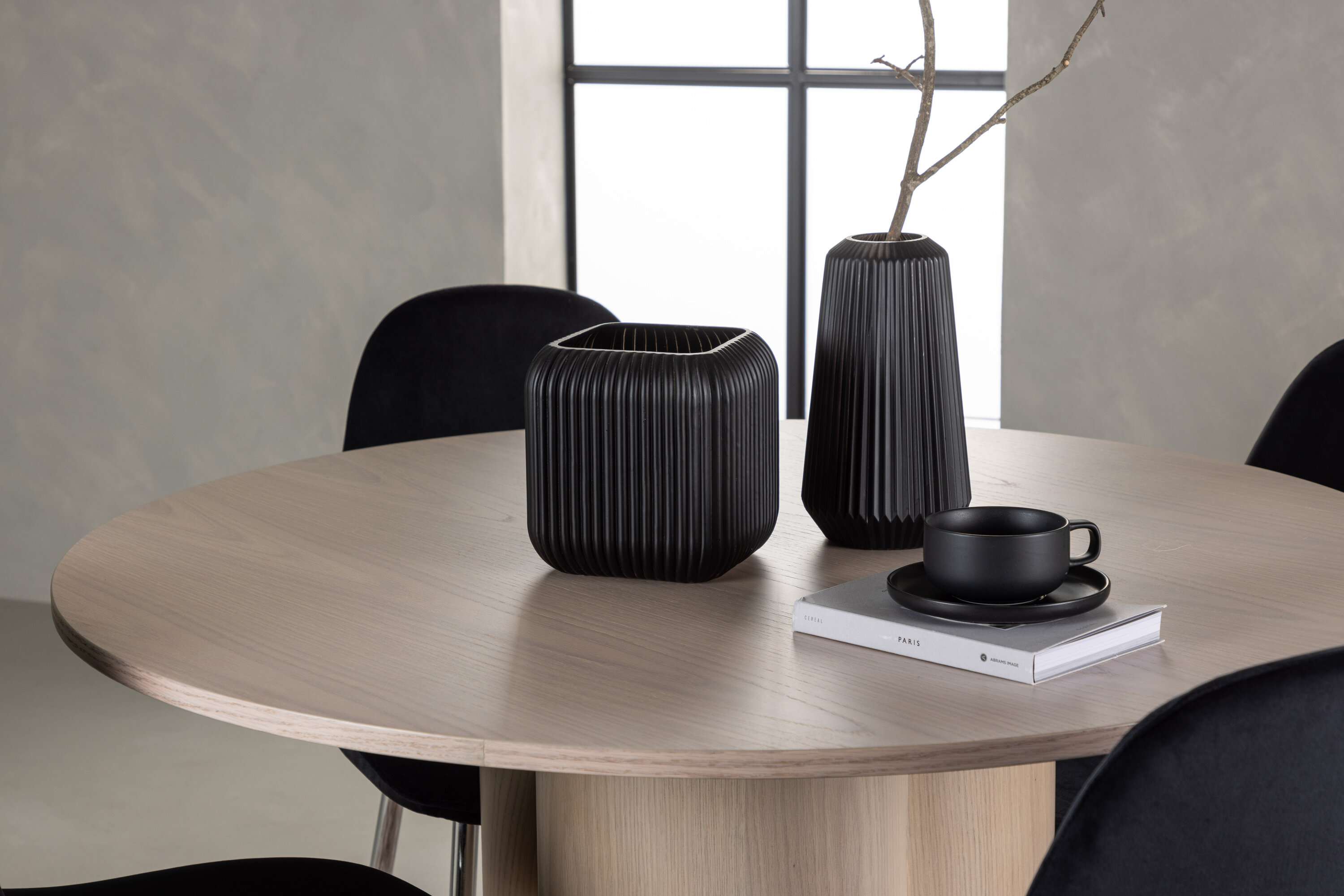 Olivia, Polar ensemble repas rond blanchi, noir, argenté Table : ⌀110 Chaise : 52 x 90 x 45 cm en situation dans une pièce décorée